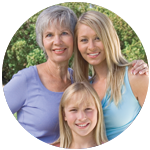 Grandmother, mother and daughter smiling.